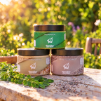 Moringa, Ashwagandha és EzüstSzüret tégely egymásra rakva egy kerti faasztalon, naplementében, előttük friss moringa ág és chia mag