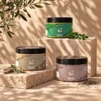 A HunzikerGarden csomag három tégelye travertin kőtömbökön, olajfalevelek árnyékában, mellettük friss moringa levél, ashwagandha gyökér és chia mag